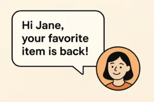 A white speech bubble with rounded corners contains the black text 'Hi Jane,' on the first line and 'your favorite' on the second, followed by 'item is back!' on the third. The speech bubble points towards a circular avatar on the right. The avatar has a light peach-colored face, short black hair, and a small, smiling expression with two dots for eyes and a curved line for a mouth. The avatar is wearing an orange shirt with a darker orange neckline and is outlined in black against a light peach background.