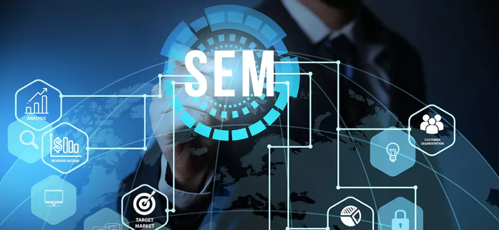 A person wearing a dark suit and tie is partially visible, with their hand appearing to draw on a transparent digital interface. The central element is a glowing, circular graphic with the white letters 'SEM' in the middle, surrounded by rotating blue elements. This central graphic is connected by white lines to various hexagonal icons arranged around it, overlaid on a blurred world map background. The icons represent different aspects of marketing, including an upward trending bar graph labeled 'ANALYSIS', a magnifying glass over dollar bills labeled 'REVENUE INCOME', a target with an arrow labeled 'TARGET MARKET', a group of people labeled 'CUSTOMER SEGMENTATION', a lightbulb, and a pie chart. The overall image visually represents the interconnected strategies and components of Search Engine Marketing on a global scale.